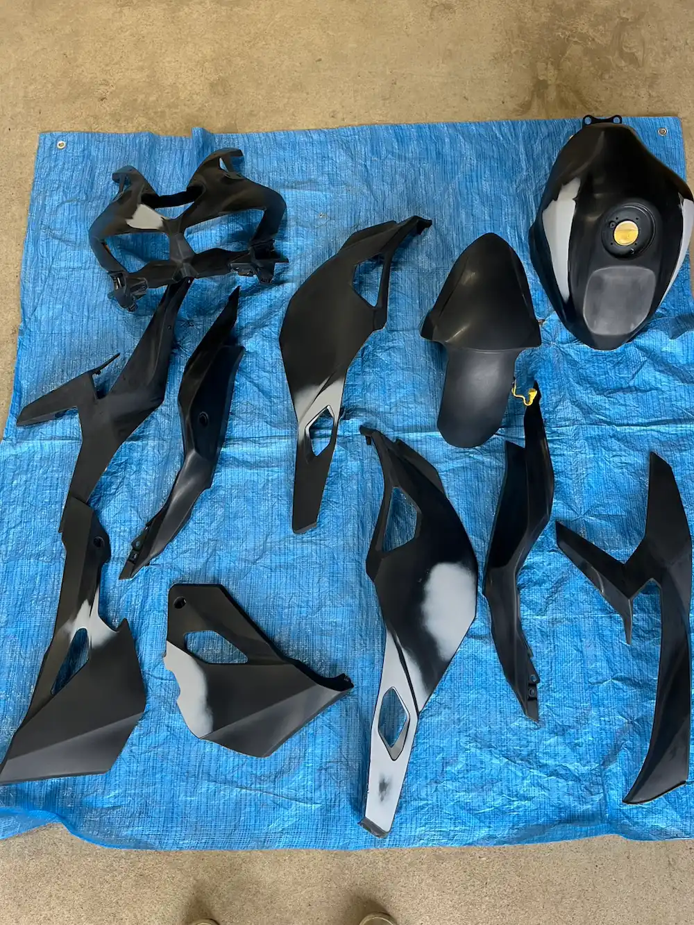 バイクのタンクを丁寧に研磨している様子